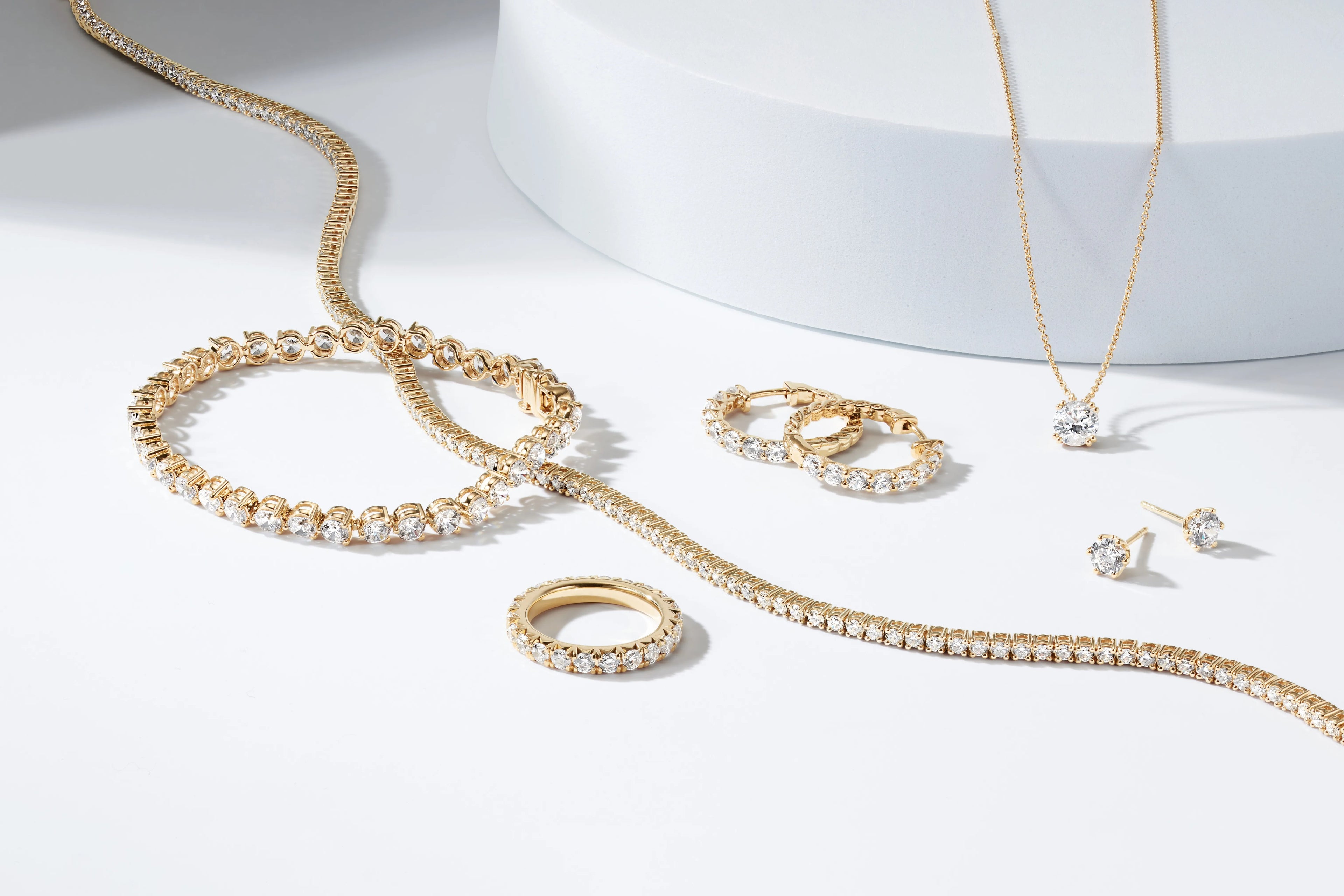 Gold jewelry set including necklace, bracelet, ring, and earrings on a white background