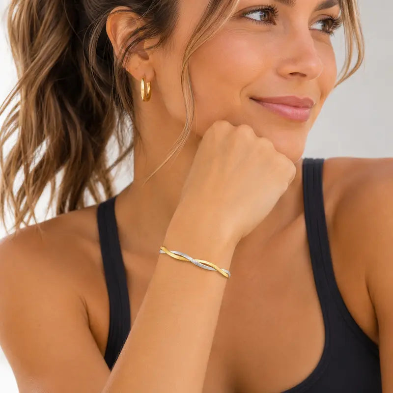 mixed metal gold and silver bracelet on woman wearing work out top.