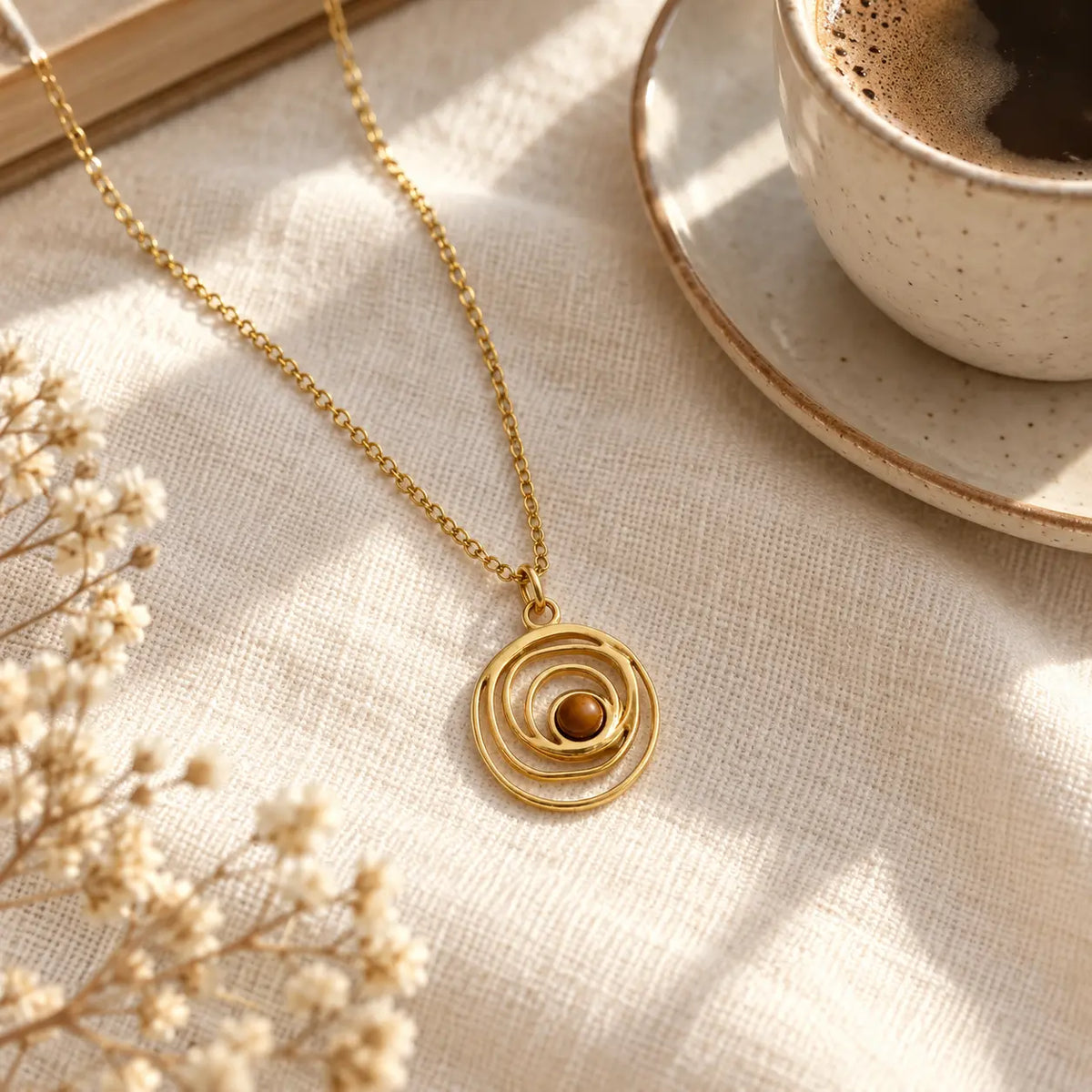 swirl gold necklace laying on coffee table