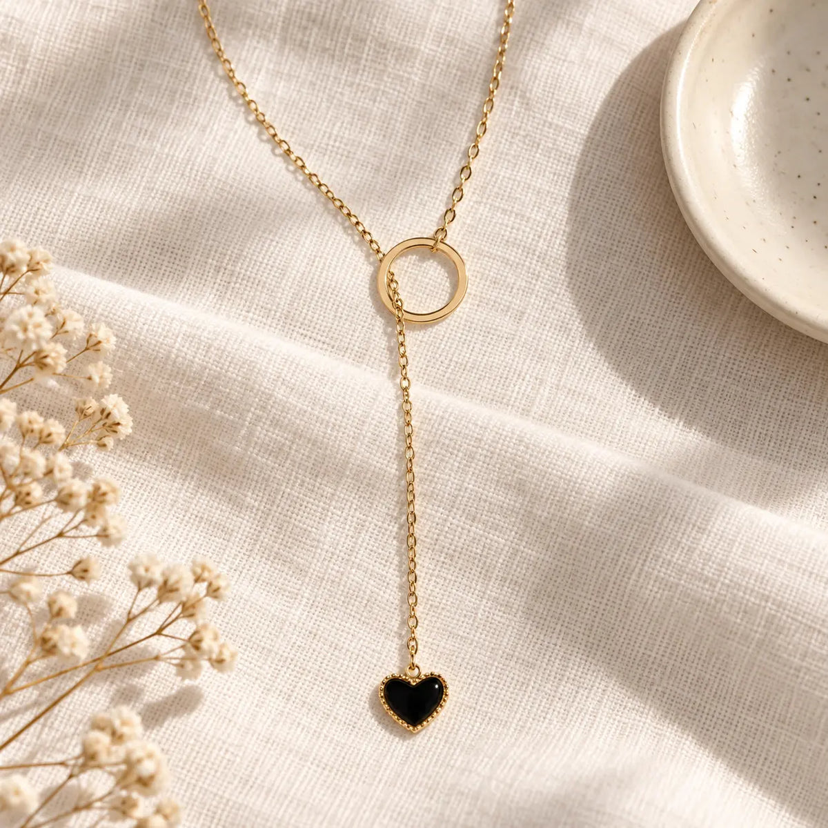 black heart necklace on white linen