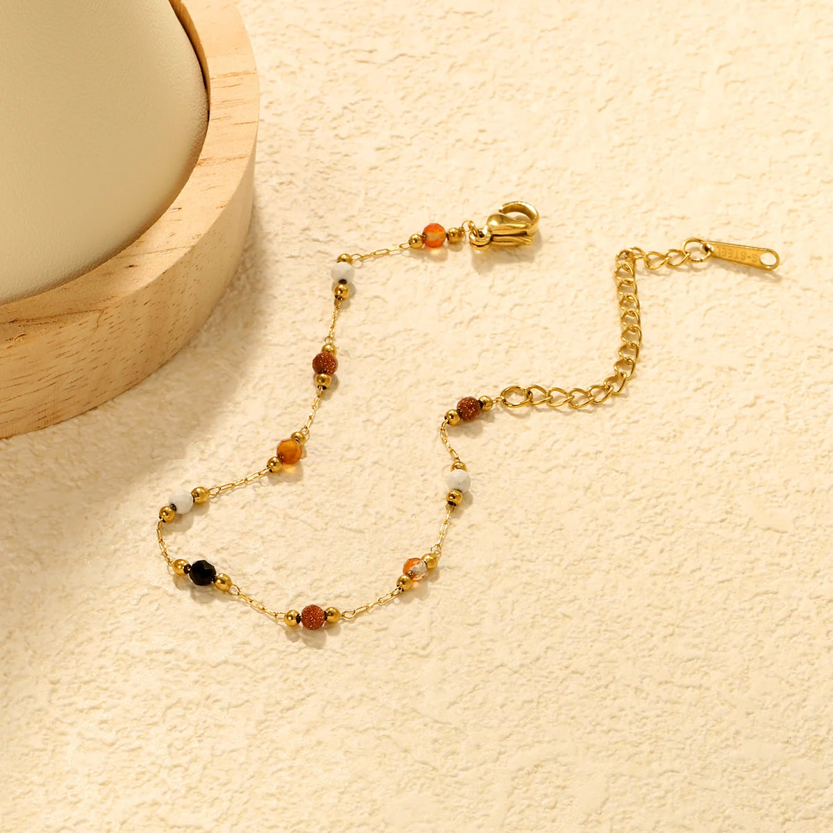 Natural Stone Beaded bracelet with beads on a beige textured surface