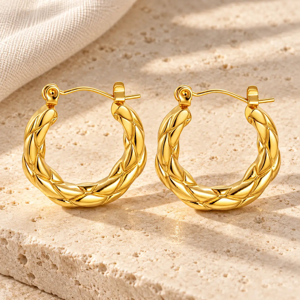 sculpted gold hoop earrings on counter top