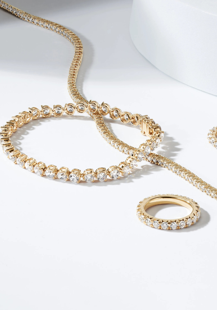 Gold necklace with diamond accents on a white background