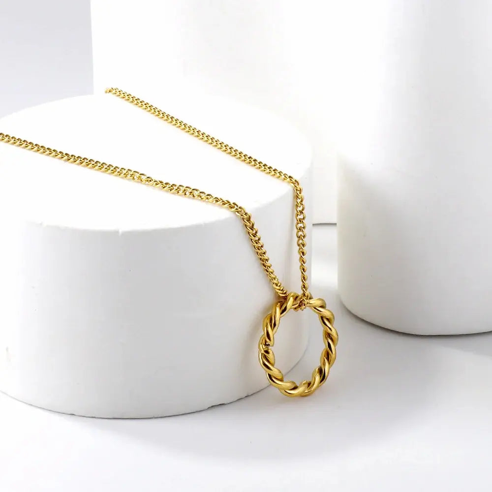 gold braided circle pendant necklac on white background